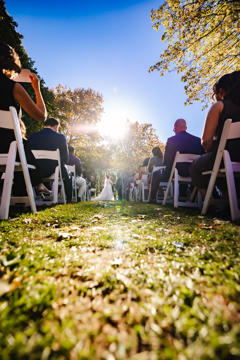 low outdoor angle of couple during ceremony, lens flare