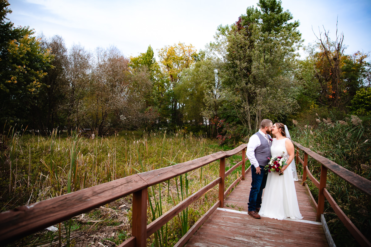 Couple smiling and hugging on a bridge during portraits