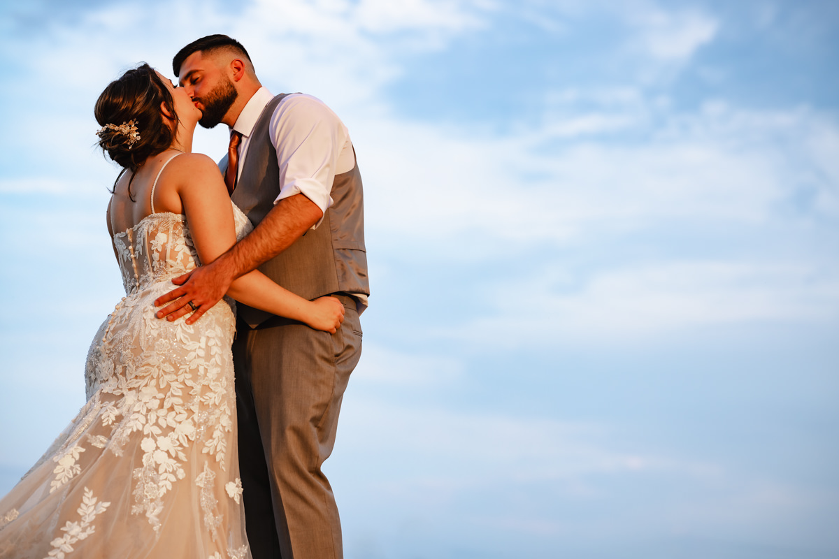 Wedding photographer finding the perfect angle to highlight couple on the blue sky.