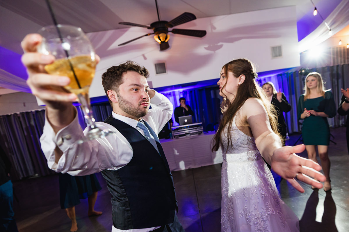 bride and groom (drink in hand) enjoying their time on the dance floor for stress-free wedding photos