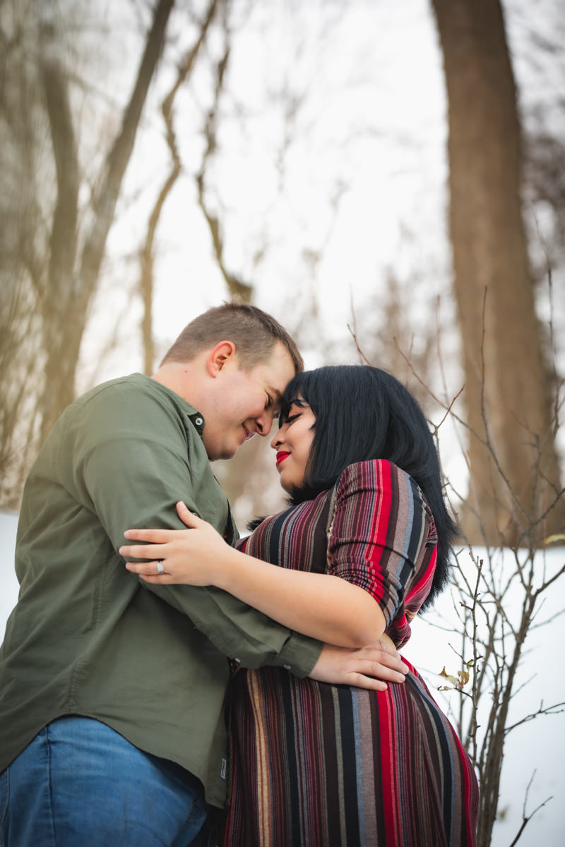 Couple with foreheads together for cozy winter session