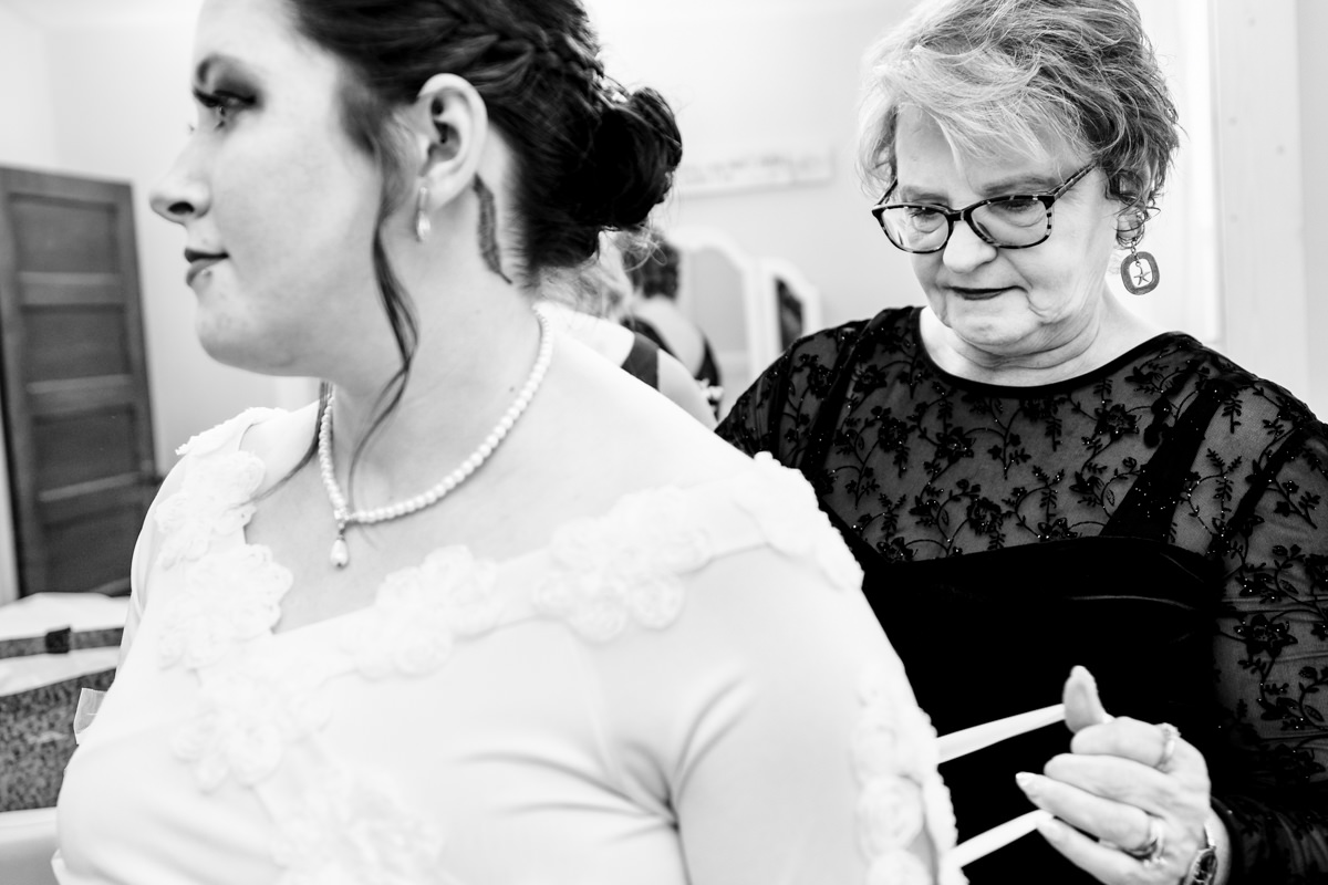 Mother helping bride into her dress at a Brown’s Orchard wedding