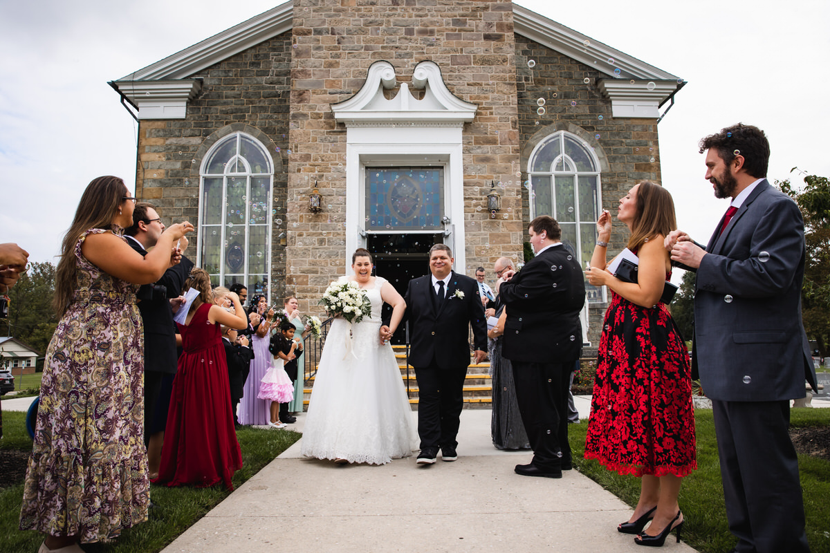 Bubbles fly through the air as couple exits church after wedding
