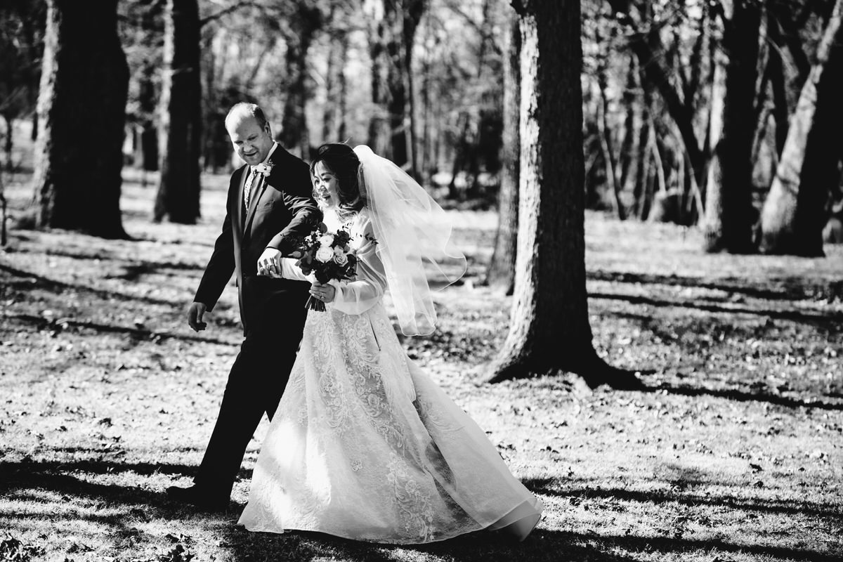 Groom and bride walking hand in hand through the beautiful property at their Cameron Estate Inn Wedding