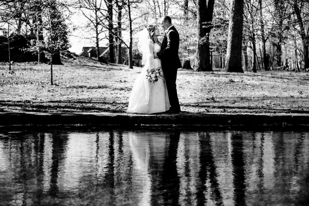 Romantic black and white image of couple standing by the water