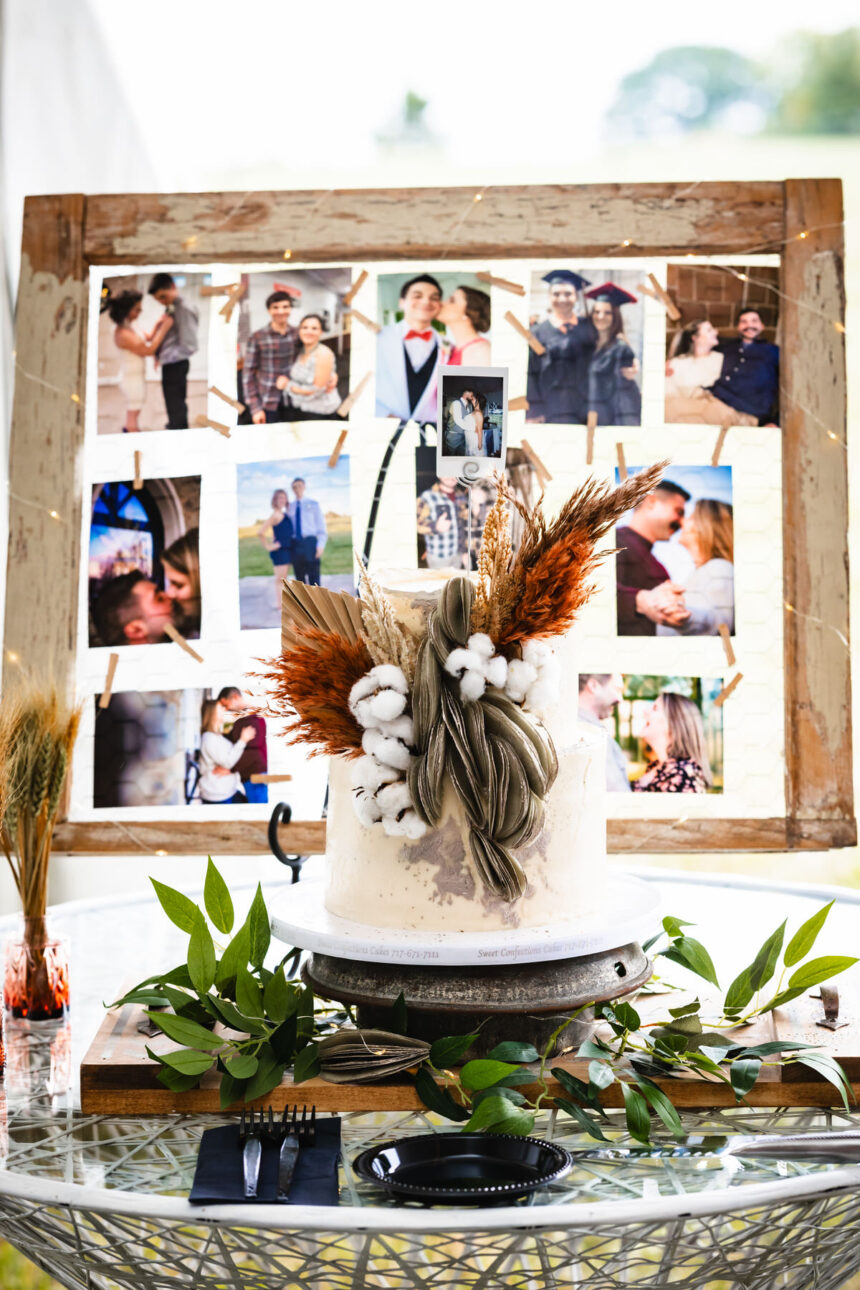 Rustic cake with feathers and cotton, barn window with photos in the background