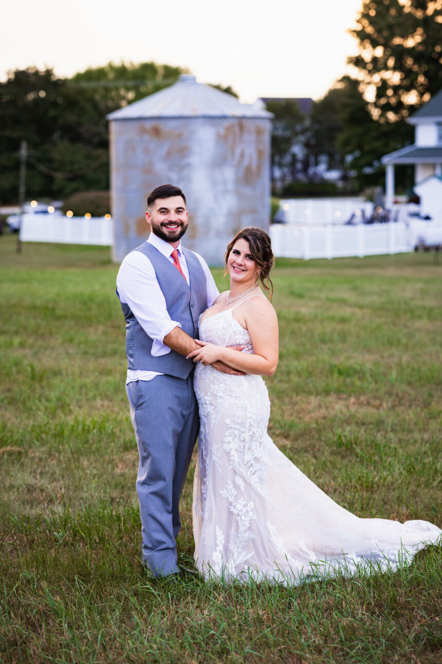 Couple posing for the camera in front of the farm silo