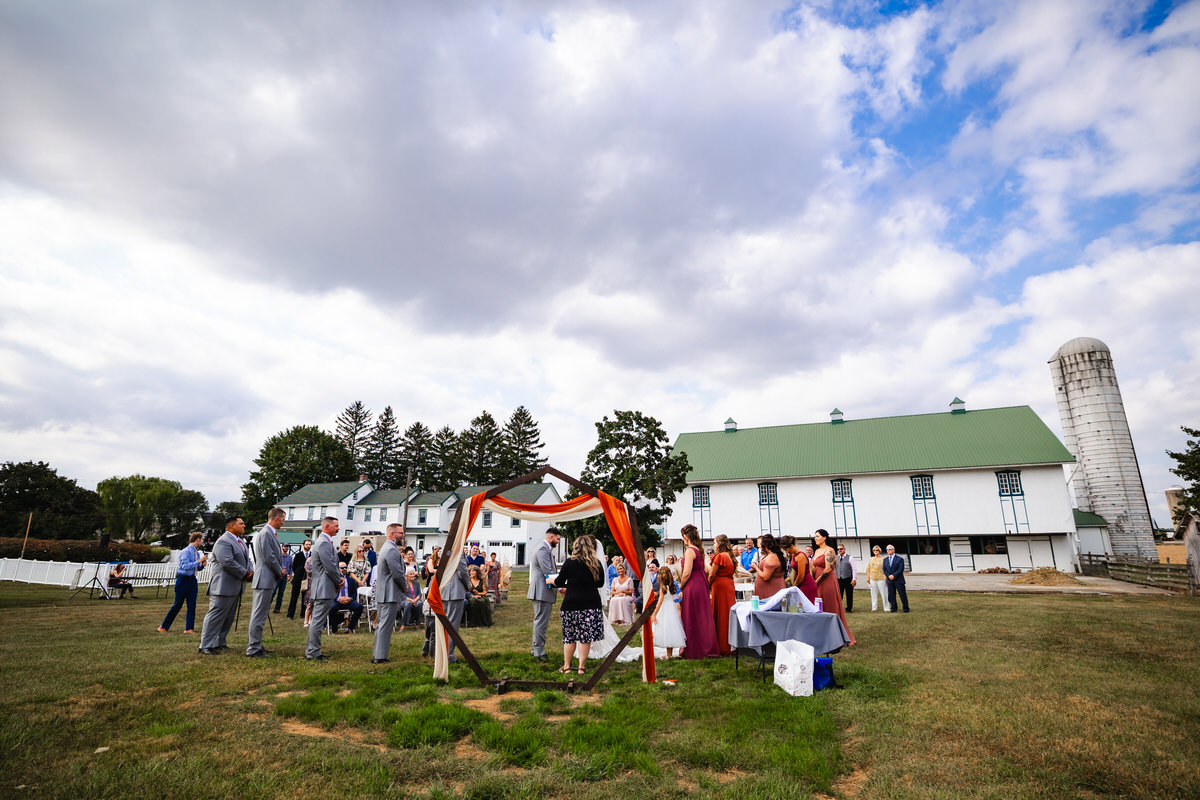 Overall view during the ceremony with an alter view to see the barn in the background