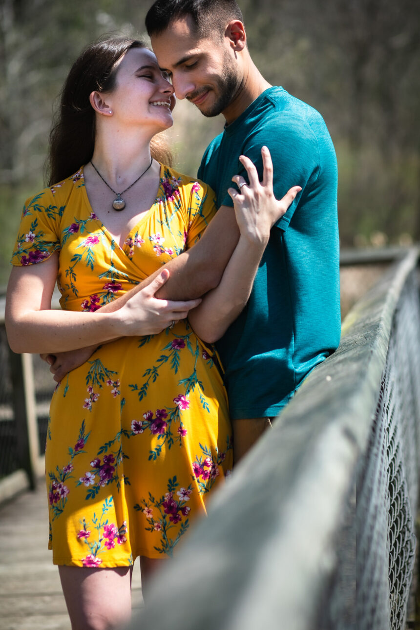 Girl whispering something funny to guy on boardwalk
