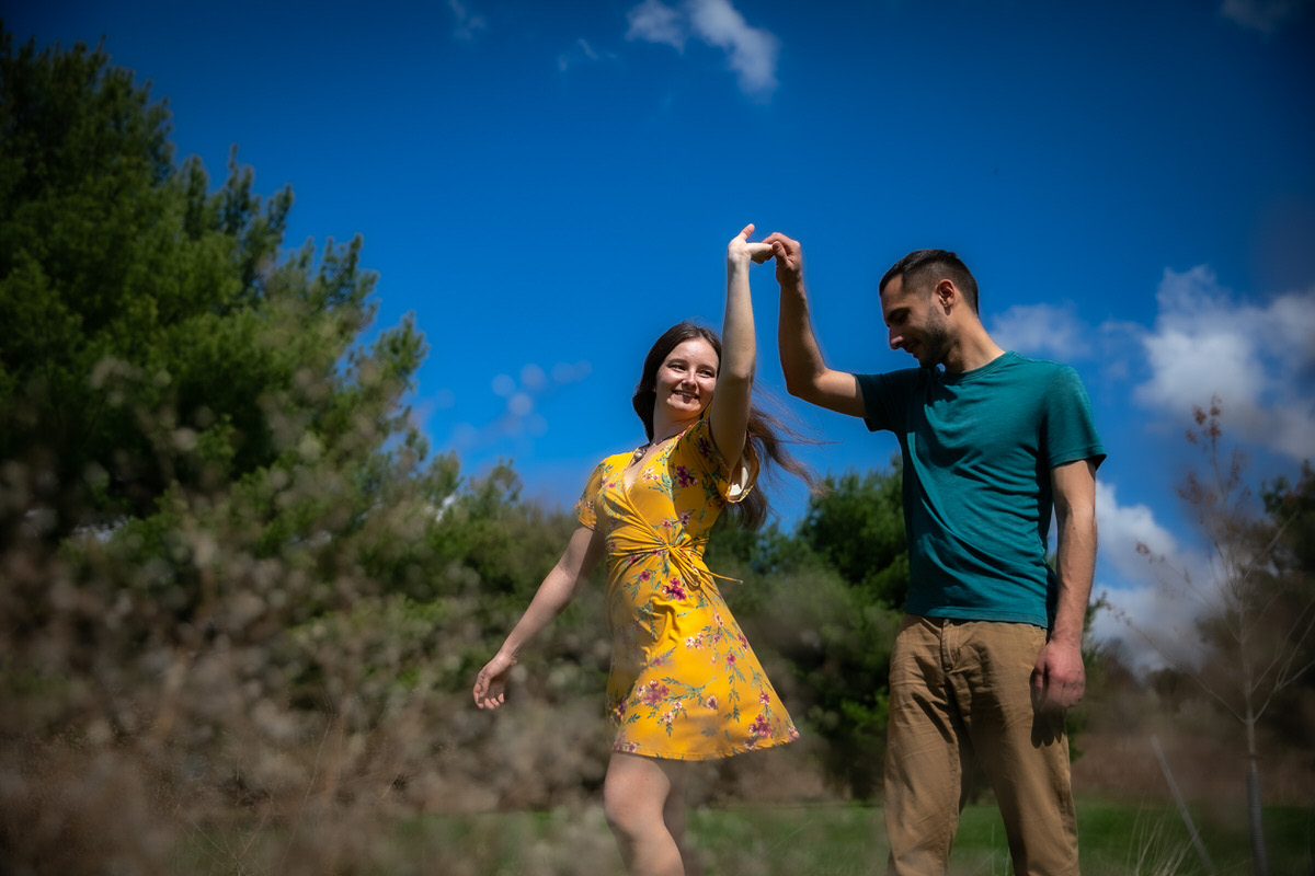 Guy twirls his fiance in the field during their Lake Redman engagement