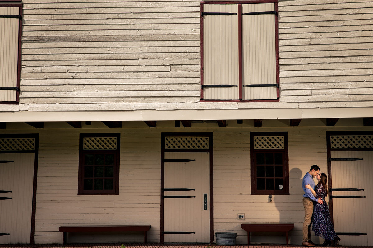 Mariah and Chris enjoying each other's embrace next to a historic barn during their Fort Hunter Engagement Photos
