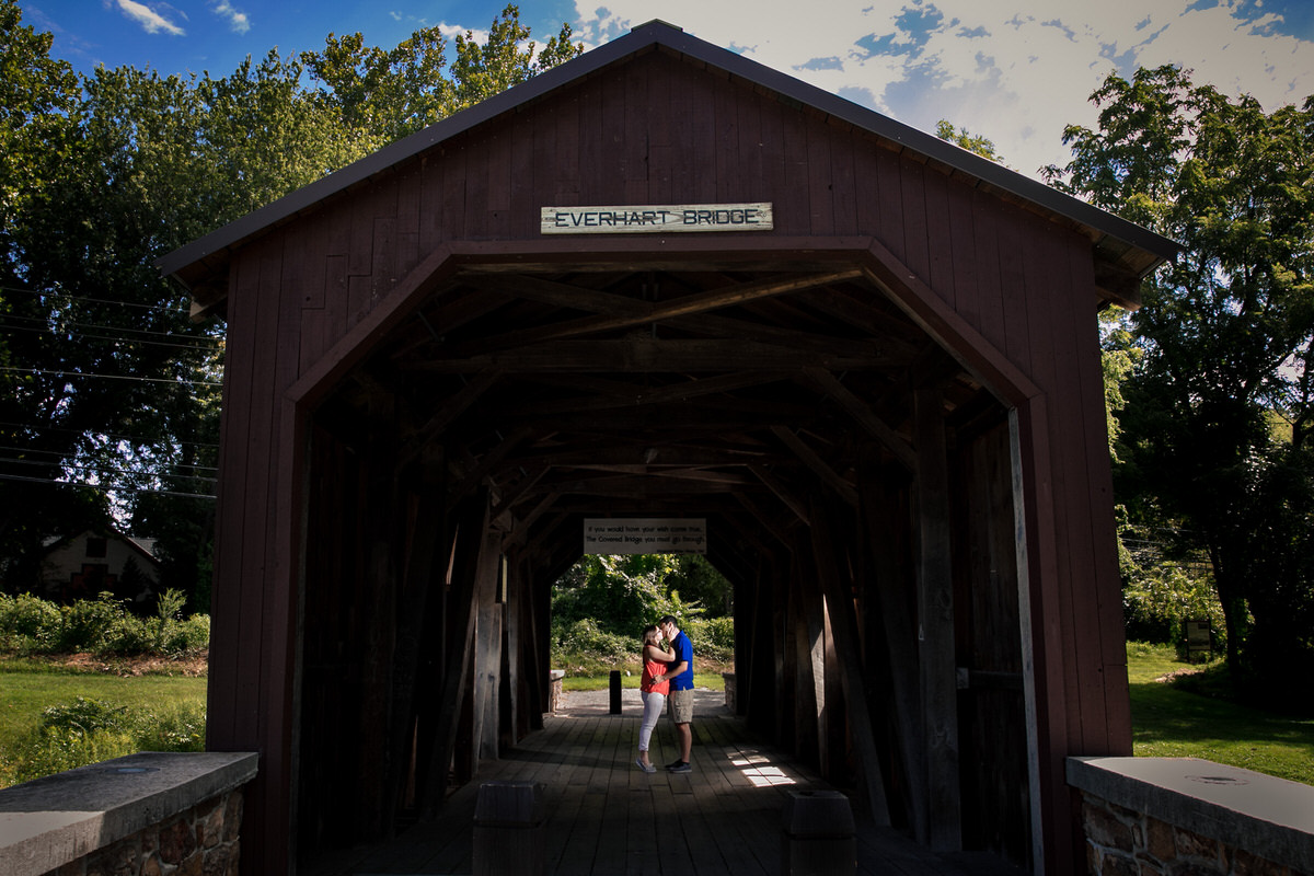 Outfit change for a photo on the covered bridge during Mariah and Chris' Fort Hunter Engagement Photos