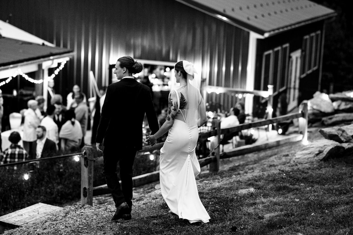 Black and white image of happy couple walking back to reception after portraits. 